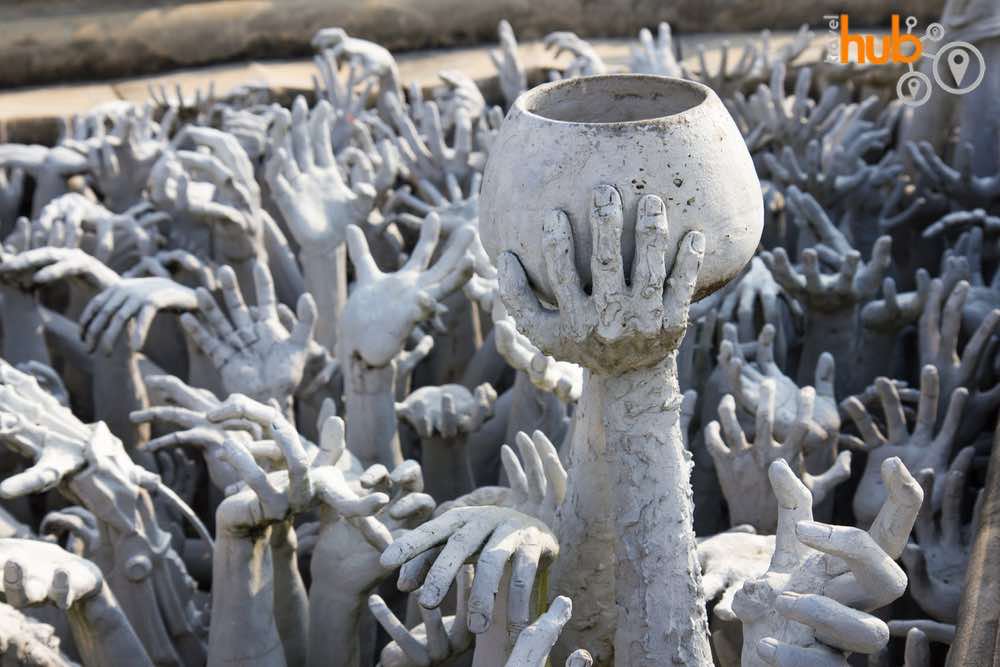 The hands sculpture can be found in front of the White Temple